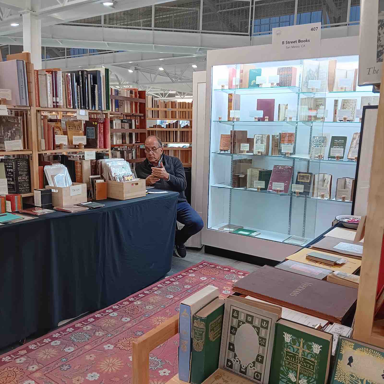 Lew Cohen at B Street Books' stand at a book fair